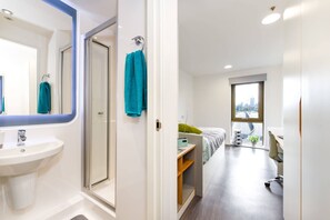 A modern hotel room with a bathroom, a bed with a view, and a desk. - Student Only Byrom Point (Liverpool)