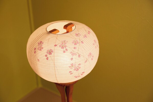 A spherical paper lantern with a floral pattern and a central opening.