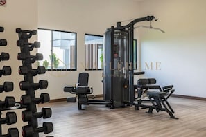 A gym with weightlifting equipment, including dumbbells and a cable machine. - Amber Cove Premier Suites Melaka (Melaka)