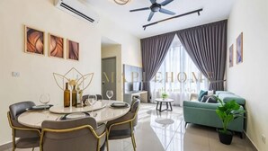 A modern living room with a dining area, a ceiling fan, and a large window with curtains. - Amber Cove Premier Suites Melaka (Melaka)