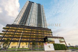 A modern building with multiple floors, large windows, and a flag. - Amber Cove Premier Suites Melaka (Melaka)
