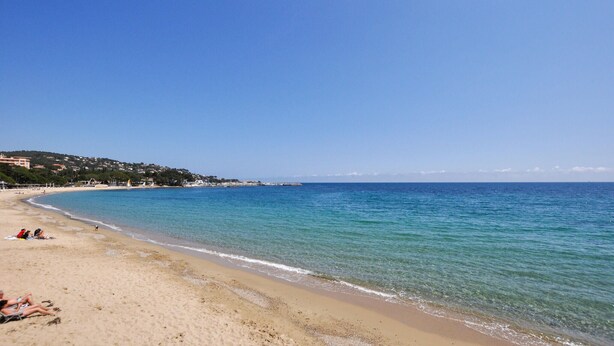 A beach with clear blue water, sandy shore, and buildings in the background. - Nice apartment in Sainte-Maxime with WiFi (Sainte-Maxime)