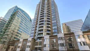 Un immeuble moderne de grande hauteur, doté d’une façade incurvée, de grandes fenêtres et d’une structure combinant verre et brique.