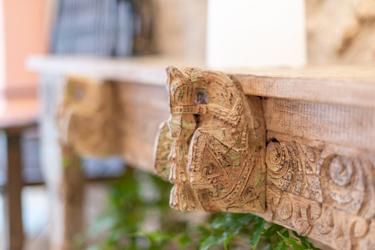 A wooden bench with carved owl figures.