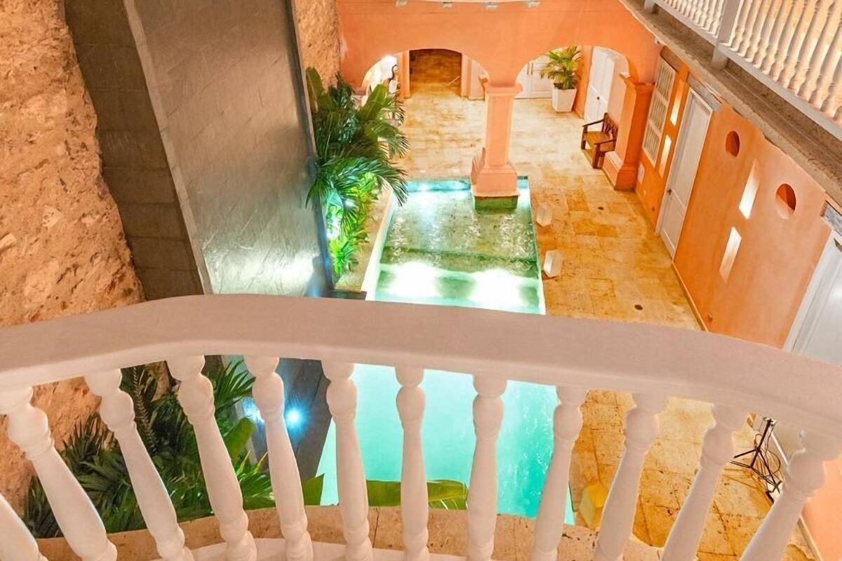 Um pátio com piscina, escadas e um edifício com varandas.