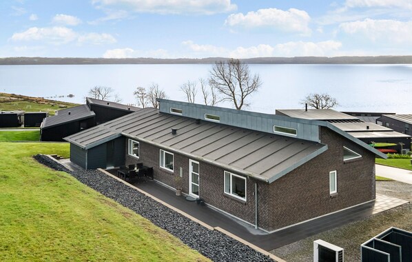 Situated in a serene lakeside setting, this building offers a contemporary aesthetic with a prominent sloped roof.