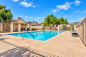A rectangular pool with a blue border, surrounded by a tiled patio.