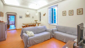 A living room with a sofa, a television, and a dining table. - Nice home in Lusignano d'Albenga (Lusignano d'Albenga)