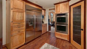 A kitchen with wooden cabinets, stainless steel appliances, and a rug on the floor. - Mountain Home with Private Hot Tub (Silverthorne)