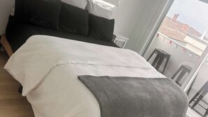 Una camera da letto con un ampio letto, un balcone vista e una finestra.