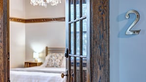 Ein Schlafzimmer mit einem Bett, einem Nachttisch, einer Lampe und der Zahl '2' an der Wand.