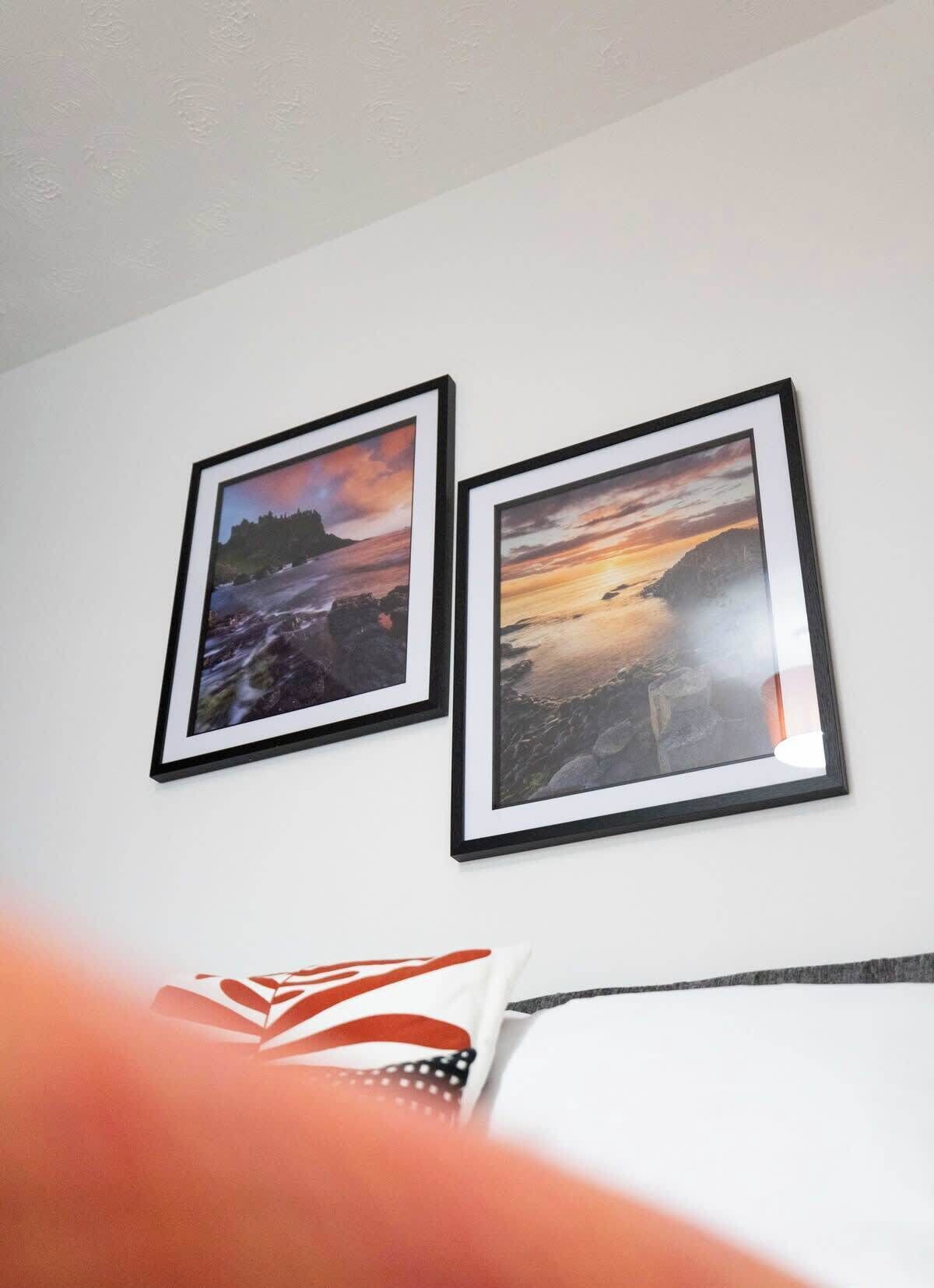Deux tableaux encadrés représentant des paysages, accrochés à un mur.