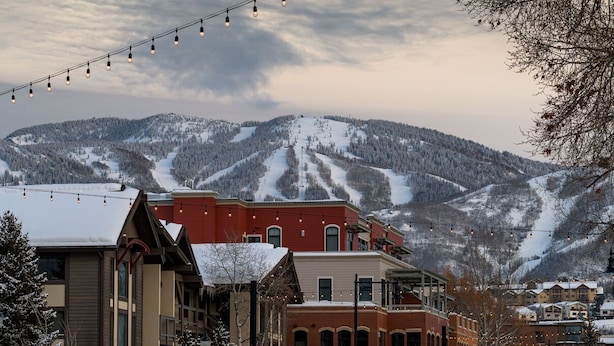 A building with a red facade and a snow-covered mountain in the background.