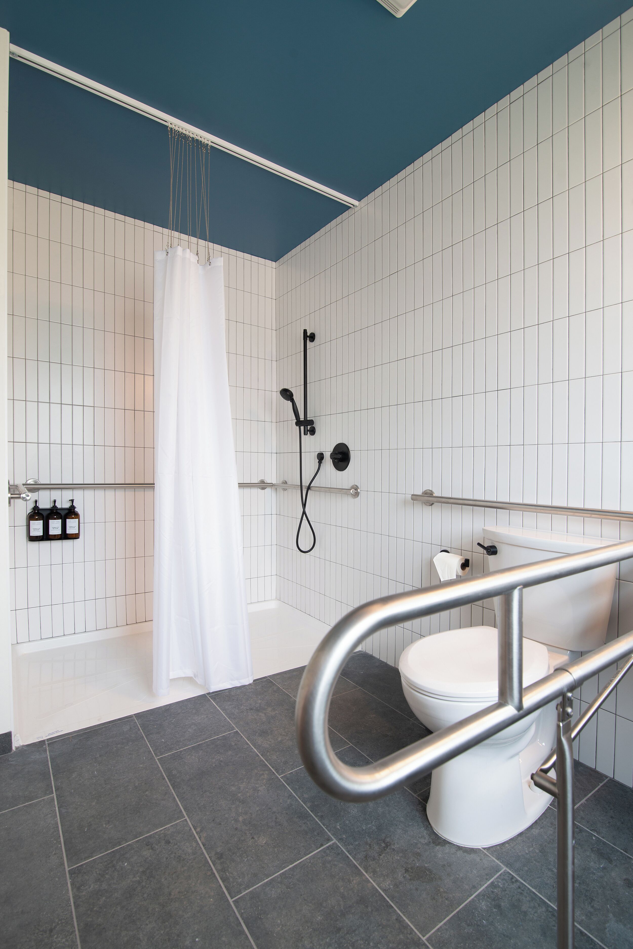 A modern bathroom with a bathtub, shower, and toilet.