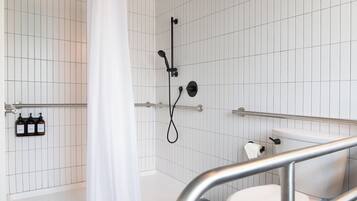 A modern bathroom with a bathtub, shower, and toilet.