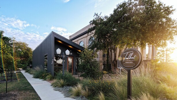 A modern building with a sign for Talbot Commons Pocket Hotel. - Talbot Commons Hotel (Taylor)