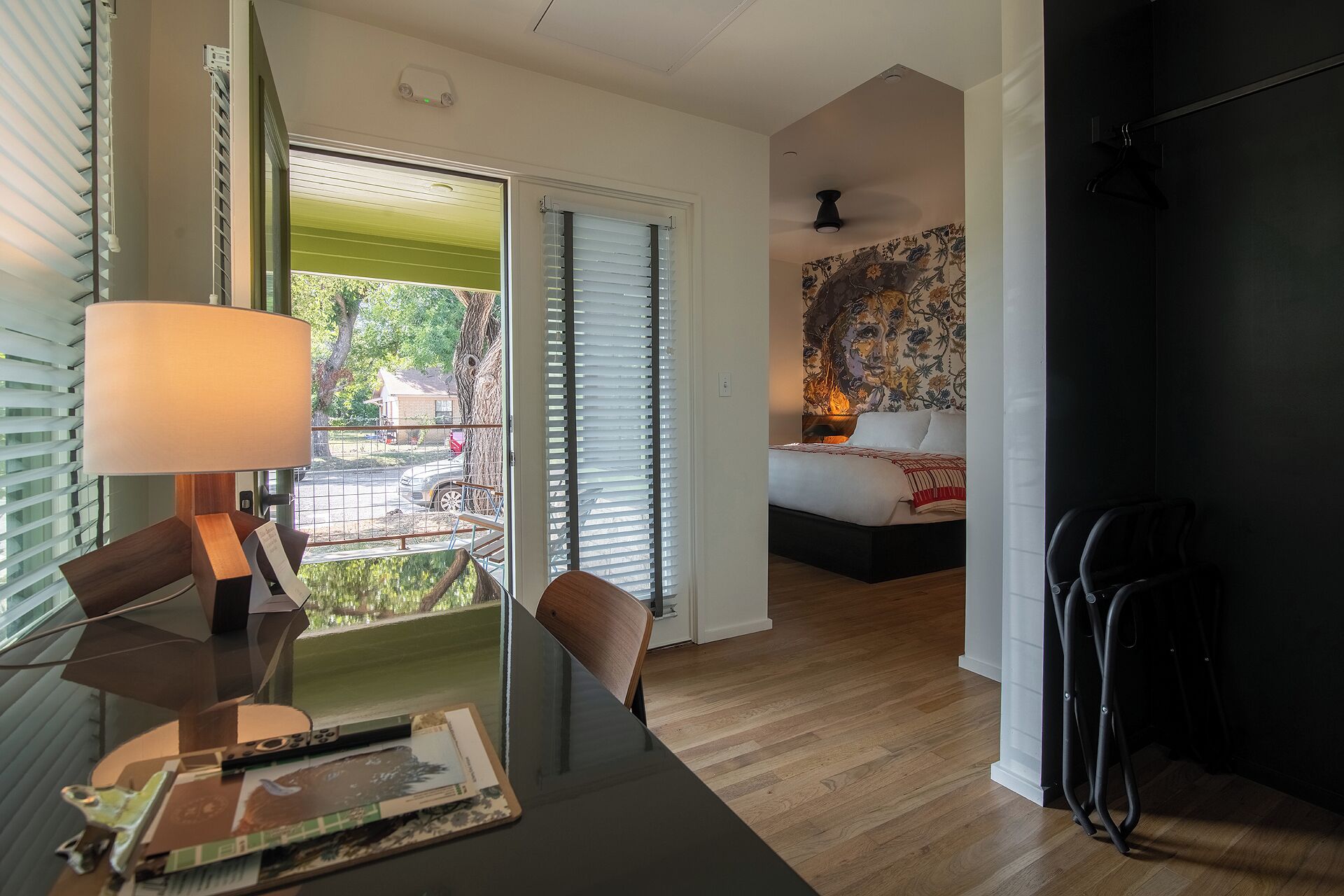 A modern bedroom with a bed, a nightstand, and a wall-mounted lamp.