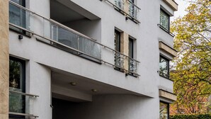 Um edifício com várias andares, varandas, janelas amplas e fachada de pedra.