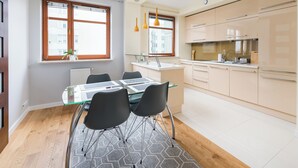 Una cocina moderna con comedor, piso de madera y vistas a la ciudad.