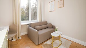 A modern living room with a sofa, a small side table, and a chair. - Urban Heart Deluxe Studio #1 (Warszawa)
