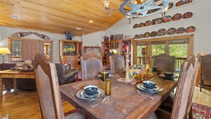 A wooden dining table set with plates, bowls, and a candle centerpiece.