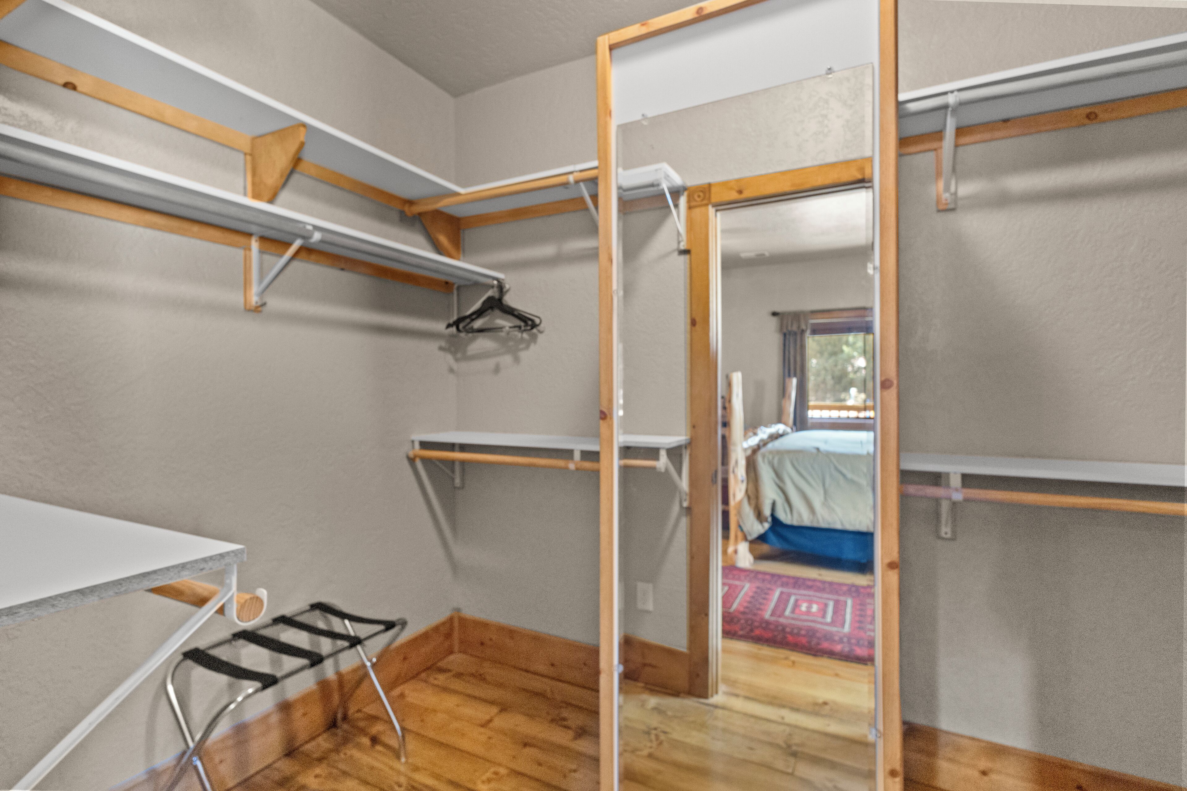 A compact room with a bunk bed, a small table, and a drying rack.