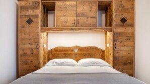 Cama com cabeceira de madeira e duas gavetas de cada lado.