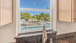 Una cocina con vista al puerto deportivo, encimera de granito y muebles de madera.