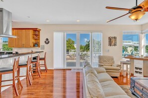 A spacious living area with a kitchen, a dining area, and a balcony with a view.