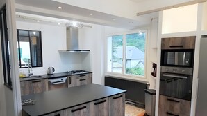 A modern kitchen with a central island, built-in appliances, and large windows. - Chalet "Sublime Chalet 14 Pers Spa Extrieur" with Mountain View (Cauterets)