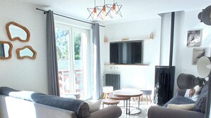 A living room with two sofas, a TV, a coffee table, and a floor lamp. - Chalet "Sublime Chalet 14 Pers Spa Extrieur" with Mountain View (Cauterets)