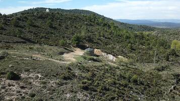 A mountainous landscape with a small structure on a hill.