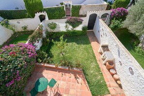 A courtyard with a paved patio, a small table, and chairs.