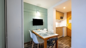 Una cocina compacta con microondas, estufa y armarios de madera.