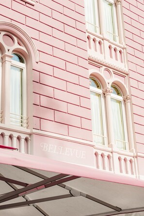 A pink building facade with arched windows and the word 'BELLEVUE' visible.