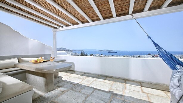 A balcony with a view of the sea, a hammock, and a table with food and drinks. - Apartment 'Casa D'irene Mykonian Residence' with Sea View, Wi-Fi and Air Conditioning (Mýkonos City)