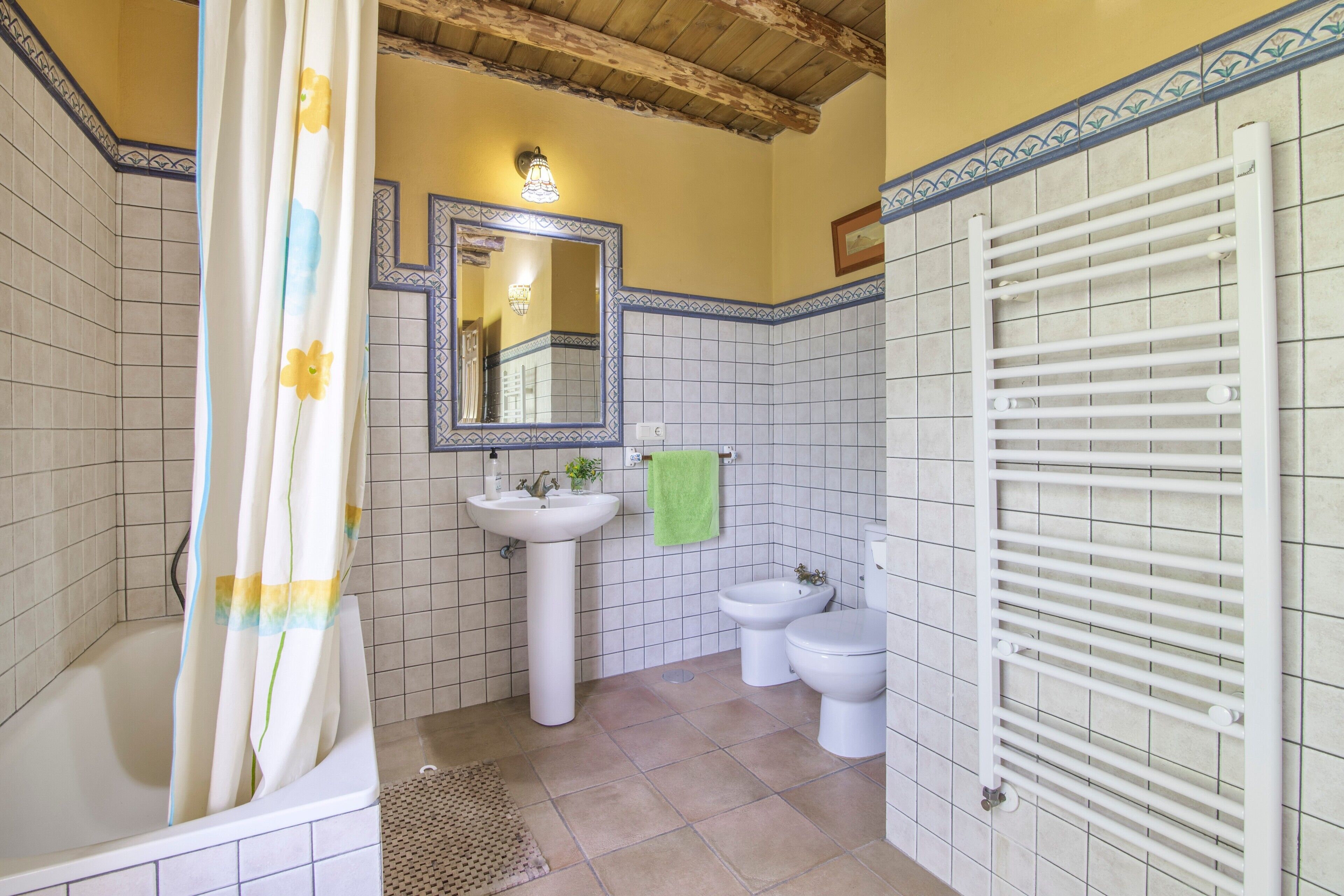 A bathroom with a bathtub, a sink, a mirror, and a toilet.
