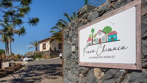 Ein Schild mit einer Hausillustration und dem Text 'Finca Chinaca ALOJAMIENTOS RURALES'.