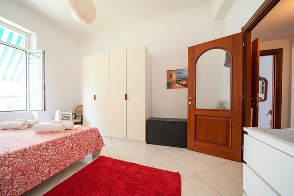 Un dormitorio con cama, armario, espejo y puerta.