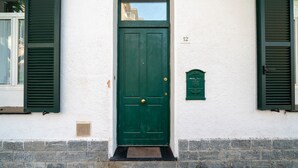 Una puerta verde con un buzón y el número 12 en la pared.