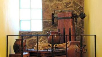A rustic room with stone walls, a window, and a metal railing.