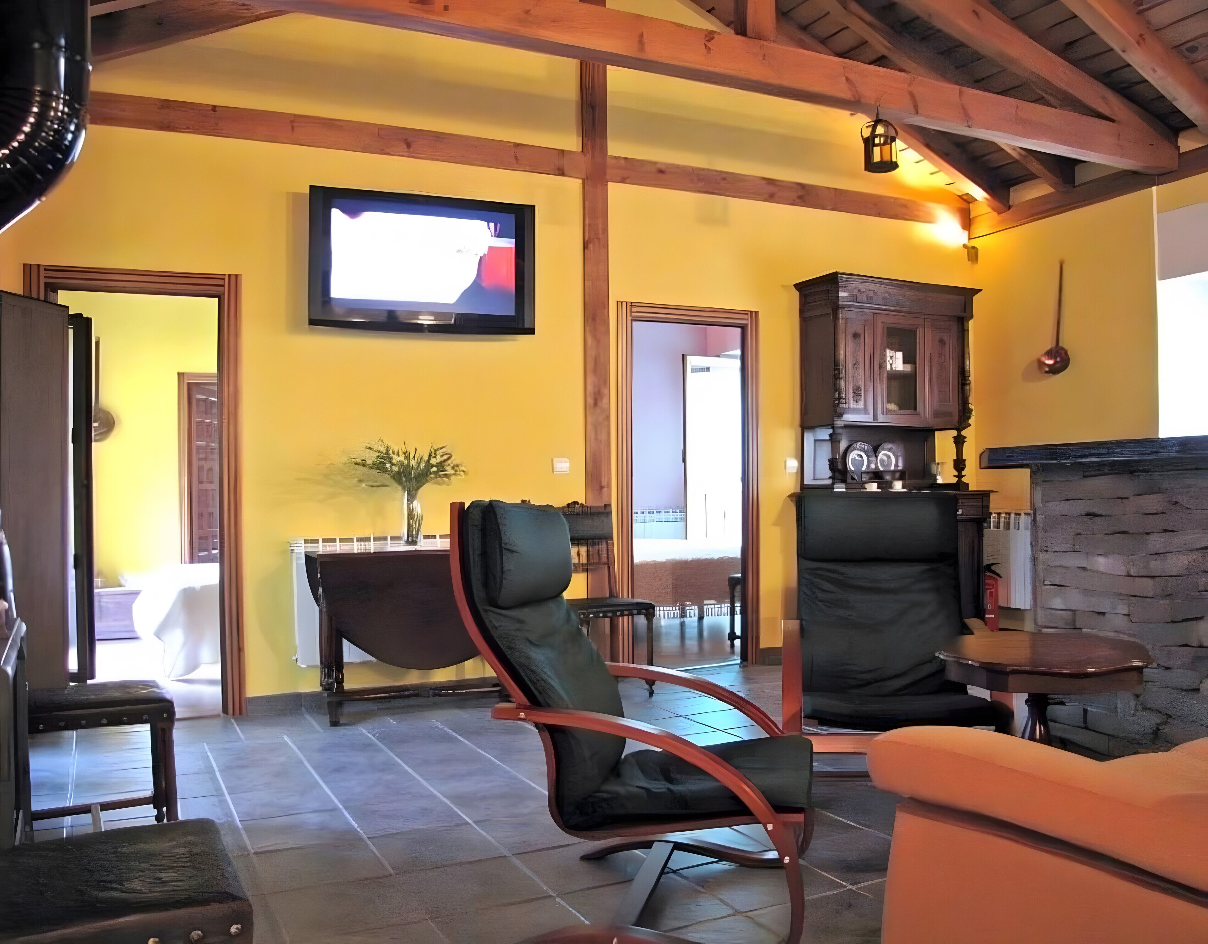 Una sala de estar con televisión, chimenea, comedor y cocina.