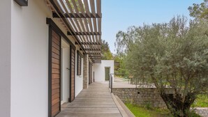 A wooden deck leading to a building with a stone wall and a tree. - Villa "Stypa" with Private Pool, Wi-Fi and Air Conditioning (Trans-en-Provence)