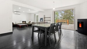 A modern living room with a dining table, sofa, and fireplace. - Villa "Stypa" with Private Pool, Wi-Fi and Air Conditioning (Trans-en-Provence)