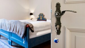 Ein Schlafzimmer mit einem Bett, einem Nachttisch, einer Lampe und einer Tür mit einem besonderen Knauf.