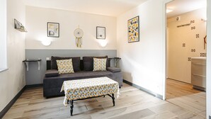 A living room with a grey sofa, patterned table, and wall-mounted decor.