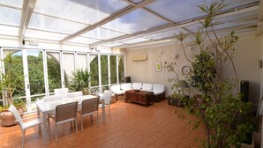 A sunroom with a glass ceiling, white furniture, and potted plants. - Holiday Home 'Casa Luisa' with Sea View, Private Pool and Wi-Fi (Betlem)