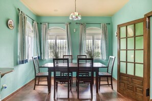 Un comedor con una mesa, sillas y cortinas.