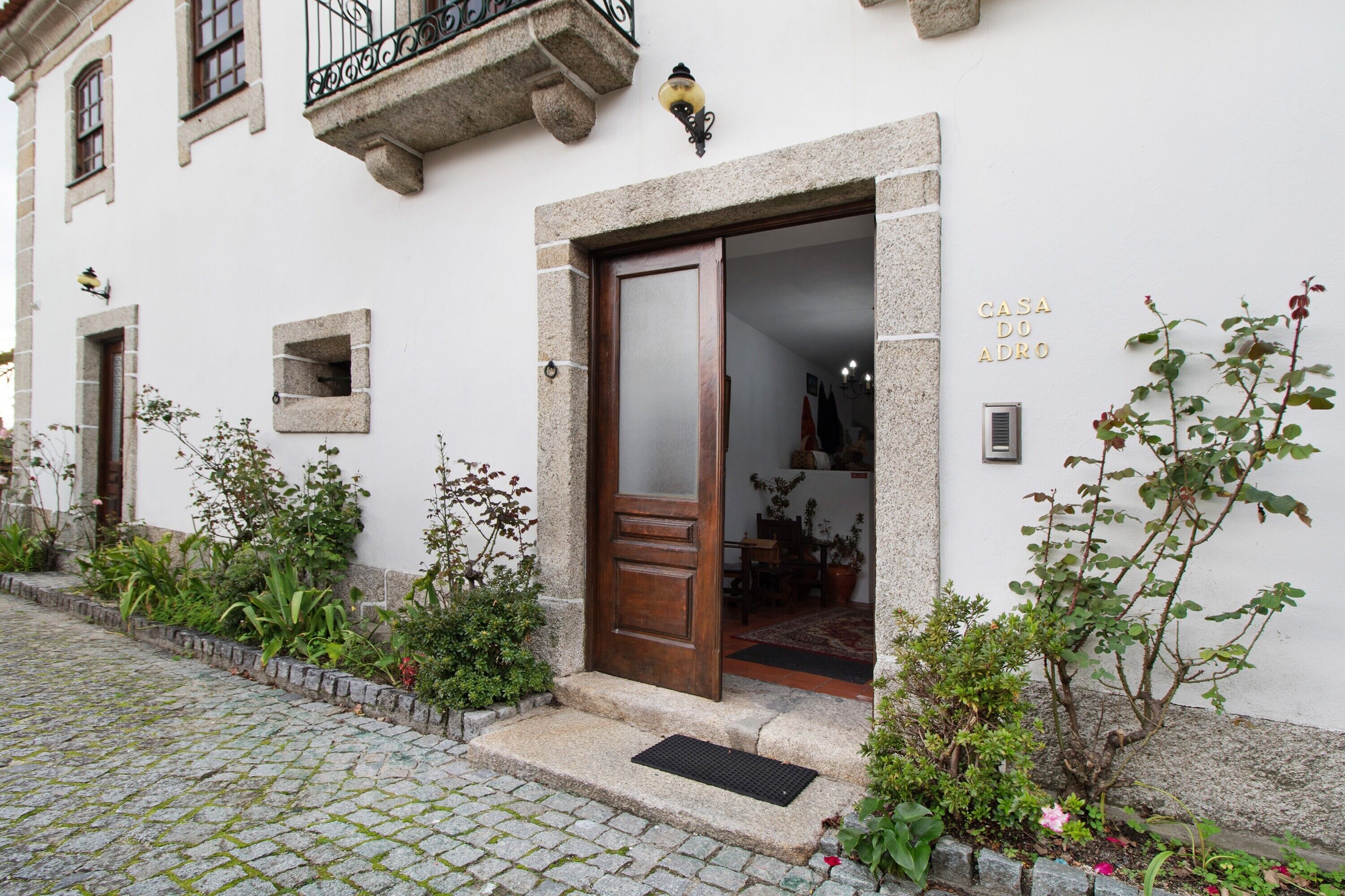 A building with a stone facade, a wooden door, and a small balcony.
