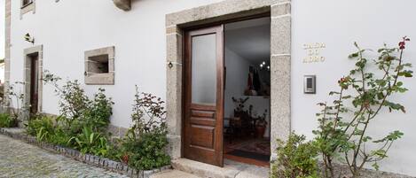 A building with a stone facade, a wooden door, and a small balcony.